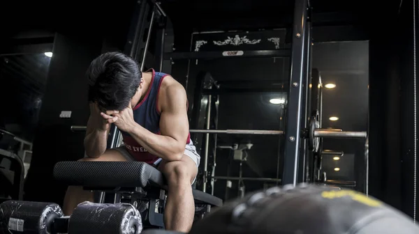 一个疲惫而沮丧的年轻人竭力想在体育馆里锻炼 — 图库照片