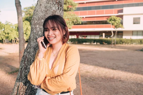 Een Aziatische Vrouw Praat Met Haar Vriendin Aan Telefoon Een — Stockfoto