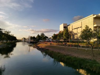 Nuvali 'deki bir çağrı merkezi binasında, manzaralı bir adamın önünde göl yapıldı. Santa Rosa, Laguna, Filipinler 'de günbatımı sahnesi.