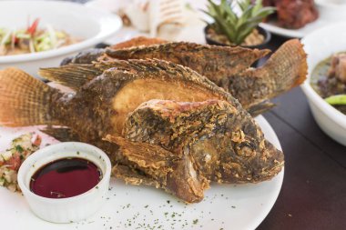 Kızarmış Tilapia, yanında da soya sosu. Filipin mutfağı. Al Fresk restoranında dolu bir öğle yemeği..