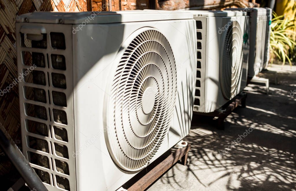 A row of Split Type Inverter Air conditioning condensers outside a cafe or restaurant. HVAC for tropical countries.