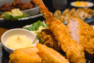 Arka planda diğer Japon mutfağı ile karışık Furai (Tavuk, Somon ve Karides) yakın plan. Bir Japon restoranında..