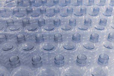 Yiyecek deposunda ya da depoda tek kullanımlık plastik su şişeleri. Bir tomar PET şişesi..