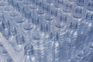 Yiyecek deposunda ya da depoda tek kullanımlık plastik su şişeleri. Bir tomar PET şişesi..