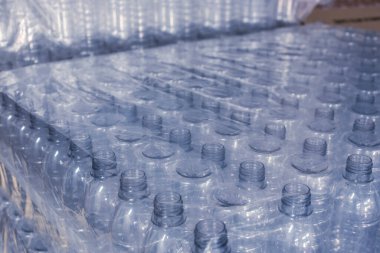 Yiyecek deposunda ya da depoda tek kullanımlık plastik su şişeleri. Bir tomar PET şişesi..