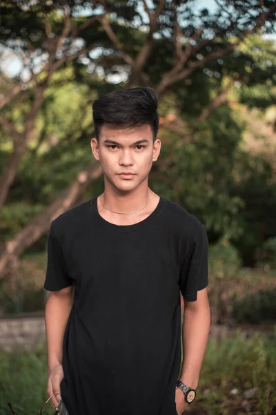 公园里一个英俊的年轻菲律宾人穿着一件黑色T恤 下午晚些时候在公园 — 图库照片