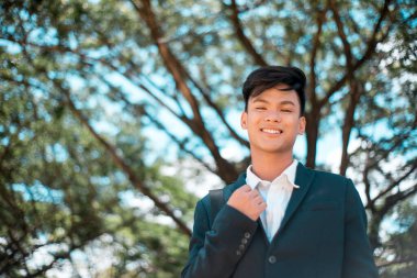 Yakışıklı ve Filipinli genç bir üniversite öğrencisi. Gülümseme ve dostça bir hava. Parkta ya da kampüste..