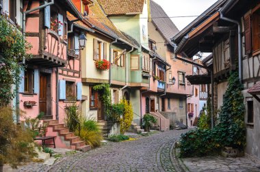 Eguisheim, Alsace, Fransa için dar bir sokakta yarı ahşap evleri