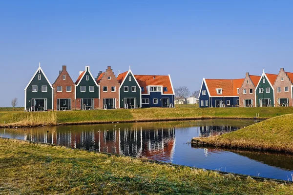 Farvede huse i marine park i Volendam afspejles i vandet på en vinter morgen, Holland - Stock-foto