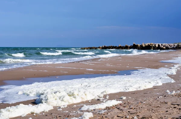 Espuma blanca sobre una superficie de agua de mar — Foto de Stock