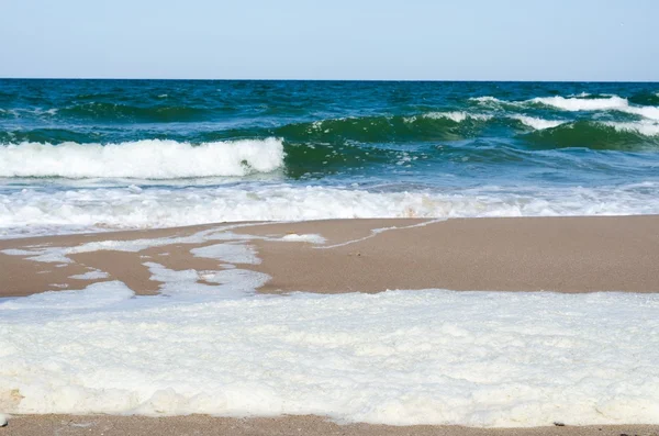 Espuma blanca sobre una superficie de agua de mar — Foto de Stock