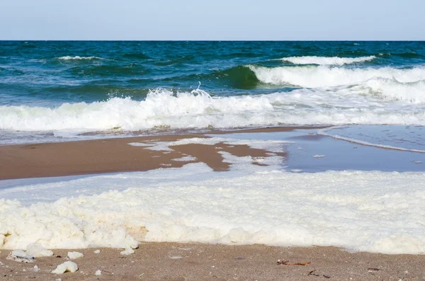 Espuma blanca sobre una superficie de agua de mar — Foto de Stock