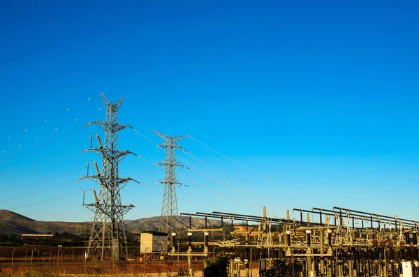 Pilones eléctricos y central eléctrica — Foto de Stock