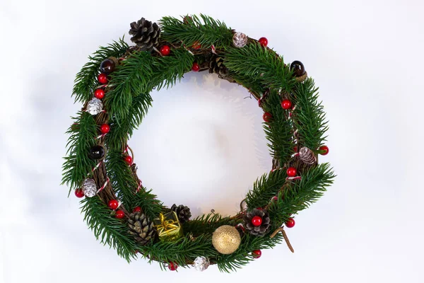 Vánoční věnce z jedlových větví, kuželů, žaludy, koule, zlatý dárek a bobule, bílé pozadí, izolované. — Stock fotografie