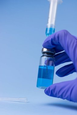 Ampula, elinde aşıyla eldiven.