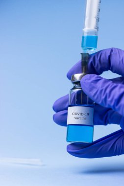 Ampula, elinde aşıyla eldiven.