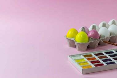 Pembe arka planda boyanmış Paskalya tavuğu yumurtaları.