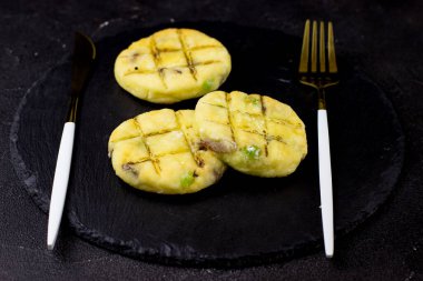 Siyah arka planda bir tabak tabakta peynirli kek.