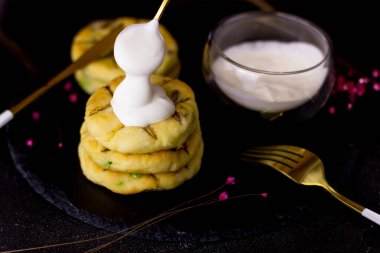 Siyah arka planda bir tabak tabakta peynirli kek. Ekşi kremalı peynirli kekler.