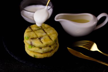 Siyah arka planda bir tabak tabakta peynirli kek. Ekşi kremalı peynirli kekler.