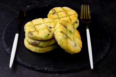 Siyah arka planda bir tabak tabakta peynirli kek.