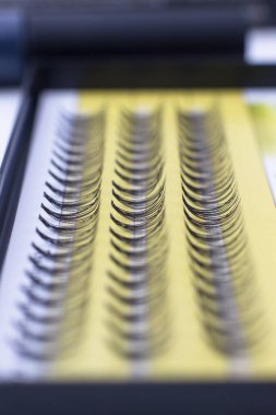 Takma kirpikler yakın plan. Beyaz bir kutuda siyah kirpikler.