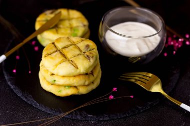 Siyah arka planda bir tabak tabakta peynirli kek. Ekşi kremalı peynirli kekler.