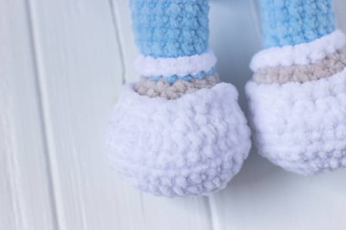 Beyaz arka planda mavi pijamalı oyuncak ayı.