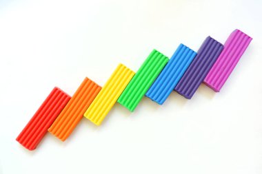 Gökkuşağının tüm renklerinin plasticine parçalarından gökkuşağının kavisini uzattı.