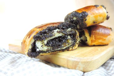 Tahta bir yüzeyde haşhaş tohumu rulosu, yakın çekim, seçici odaklanma