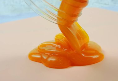 turuncu balçık kavanozdan ahşap bir yüzeye doğru akar, seçici bulanıklık