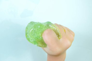 Çocukların elinde yeşil parıltılı sümük. Çocukların popüler oyuncağı..