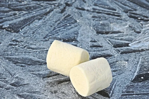 mouth watering marshmallow on the patterned cold ice. marshmallow  cream colored