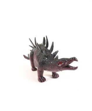 Beyaz arkaplanda Centrosaurus adında bir oyuncak dinozor, seçici bir odak noktası var.