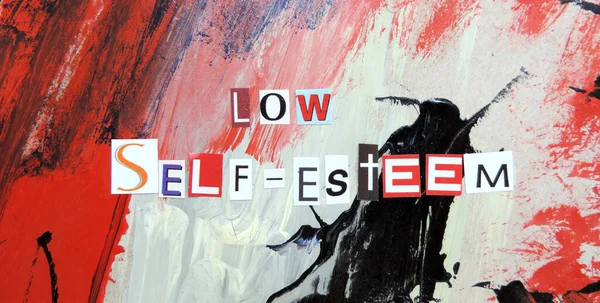 cut out of letters magazines compiled the word low self-esteem on an abstract colorful background