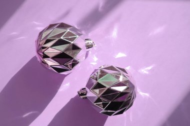 Noel kompozisyonu. Noel gümüş topları, rengarenk arkaplanda dekorasyonlar ve yüzeydeki fotokopi alanındaki ışığın güzel yansımaları. minimalist