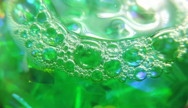 Crystalline bubbles , foam bubbles on the surface of green liquid close-up , selective focus