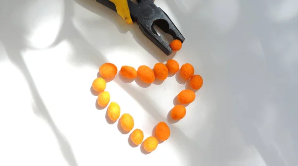 오렌지 유약에 견과류는 모양으로 배열되어 견과는 펜치에 고정되어 — 스톡 사진