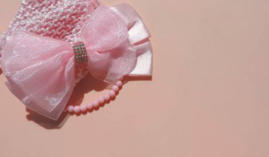Pembe kızın yayı ve pembe arka planda boncukları, çocuk yatağı. Çocukların mücevherleri, saç aksesuarları, küçük kızlar için aksesuarlar.