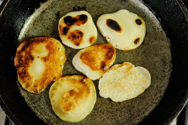 Burnt pancakes  in old cast pan on kitchen stove.  homemade  food closeup