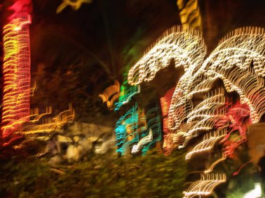 Parlak çelenkleri olan palmiyelerin hareketli gece manzarası