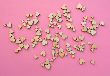 Pastel pembe arka planda ahşap kalplerle uzayı kopyala. Tatil afişi, web posteri, broşür, tebrik kartı, kapak. Romantik arkaplan