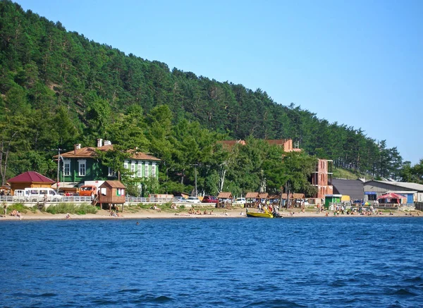 Baykal Gölü 'nden Listvyanka köyü manzarası. Kumsaldaki konutlarda oteller ve kumların üzerinde birçok turist güneşleniyor.