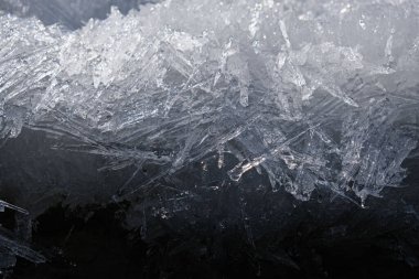 Tek renkli donuk arka plan, ışık ve gölgeli. Nehirde kışın iğne şeklinde büyük buz kristallerinin saçılması. Karanlık ve Açık