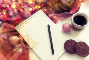 Bulanık Noel arkaplanı, kahve, not defteri, sıcak battaniye ve değerli oyuncaklarla dolu natürmort hayat kompozisyonu