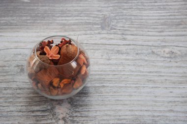 Açık arkaplanda cam vazoda kurumuş çiçekler.