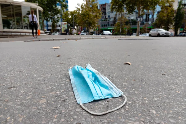 Gereksiz yere atılmış tıbbi maske. Sokağa atılmış. COVID-19 atık yönetimi ve kirlilik kavramı. Boşluğu kopyala.