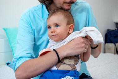 Genç baba oğlunu giydiriyor..