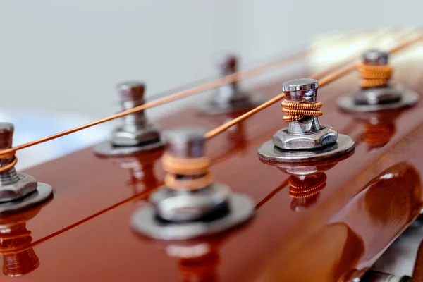 Guitar head with tuning heads. Musical instruments and music art concept. Selective focus on the pegs with the strings wind on. Close up.