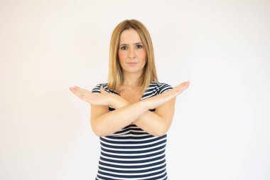 Genç bir kadın beyaz arka planda reddedilme pozu veriyor.